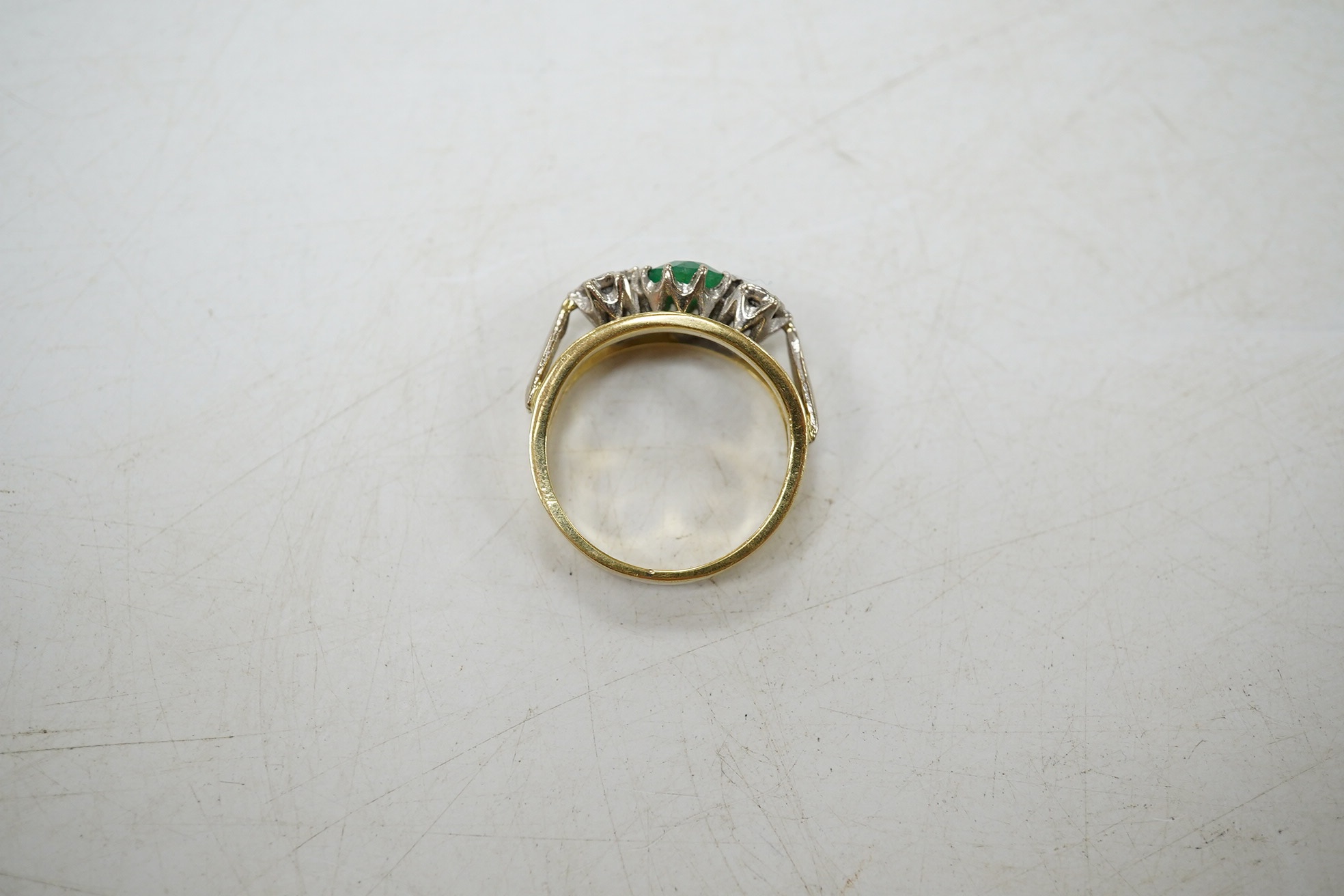 A modern yellow metal, emerald and diamond set three stone ring, size G, gross weight 3.8 grams. Condition - fair